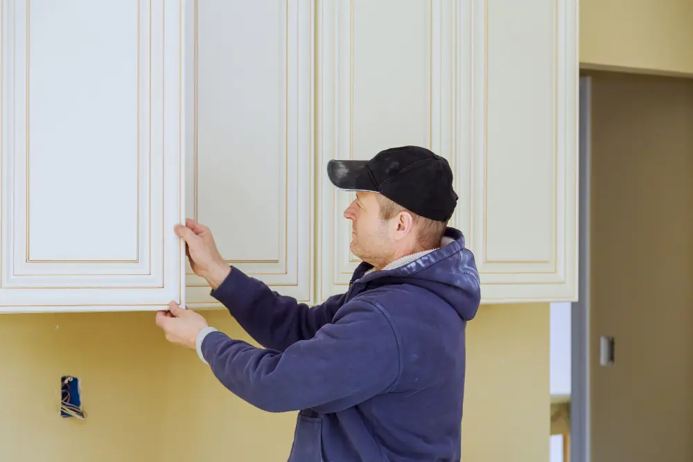 Professional installer fitting cabinet doors during a kitchen renovation
