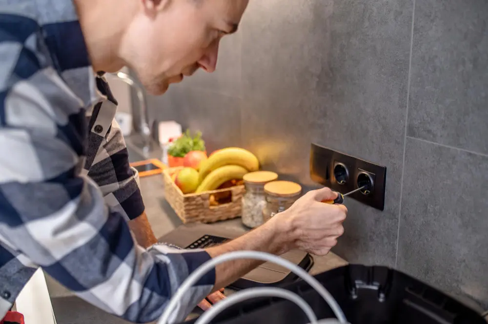 Electrician installing a power point on a kitchen splashback for appliance access in Melbourne