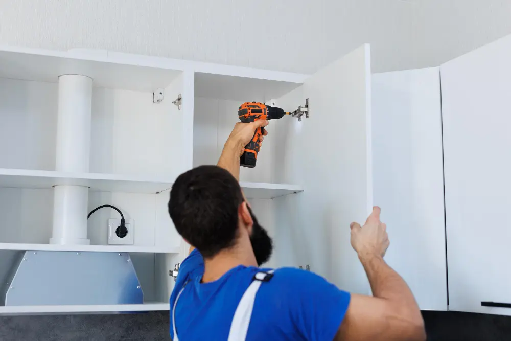 Professional installer fitting kitchen cabinet doors and hinges during a Melbourne kitchen renovation